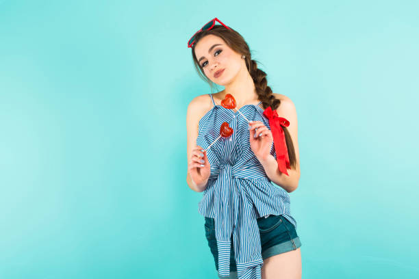 istock Young woman with heart-shaped lollipops 927256818