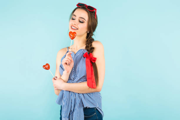 istock Young woman with heart-shaped lollipops 927256838