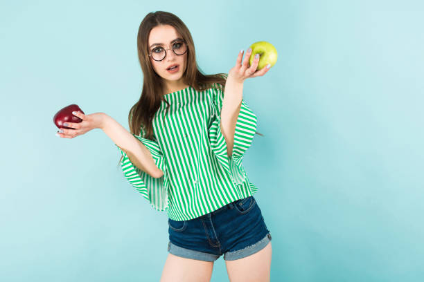 istock Young woman with two apples 927256914