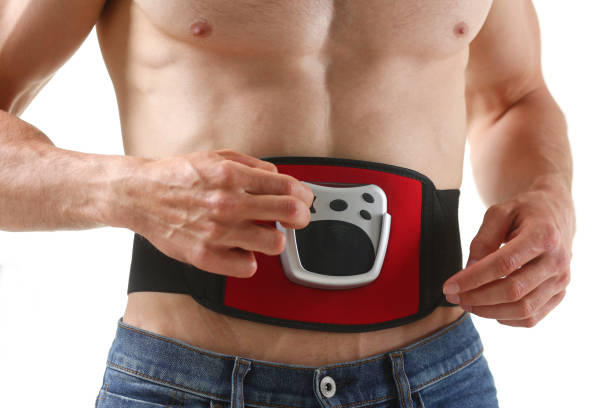 athletic folded man uses an electric - abdomen abdominal muscle muscular build beautiful imagens e fotografias de stock