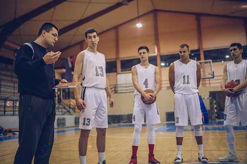 Members of male basketball team talking with coach before the game