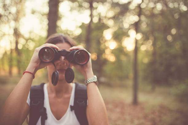 istock Female explorer looking through binoculars in the forest 927268722