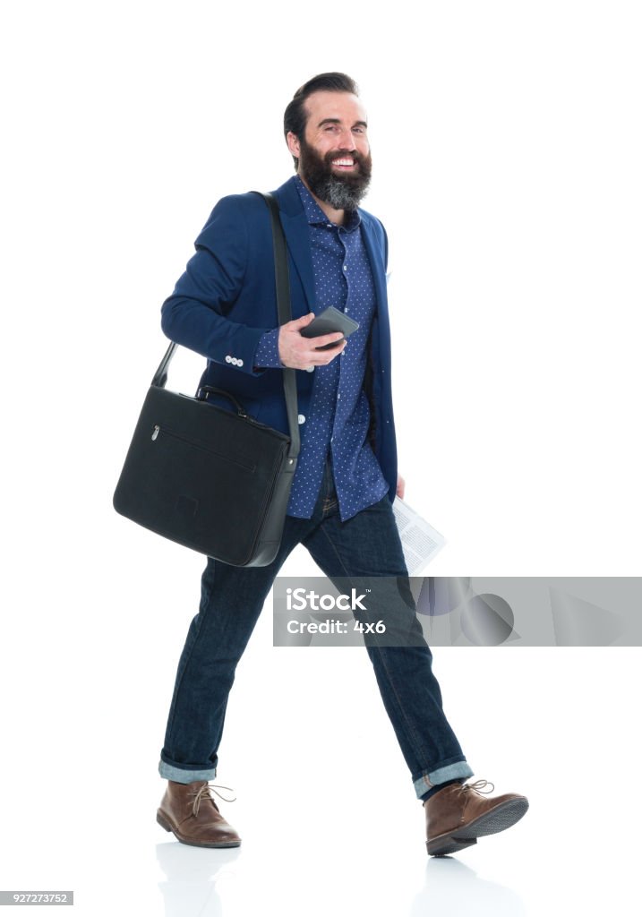 Man with beard holding bag and phone and walking Man with beard holding bag and phone Walking Stock Photo