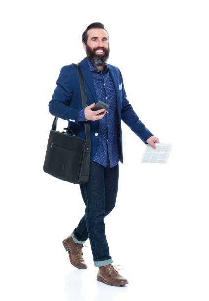 istock Man with beard holding bag and phone and walking 927273760