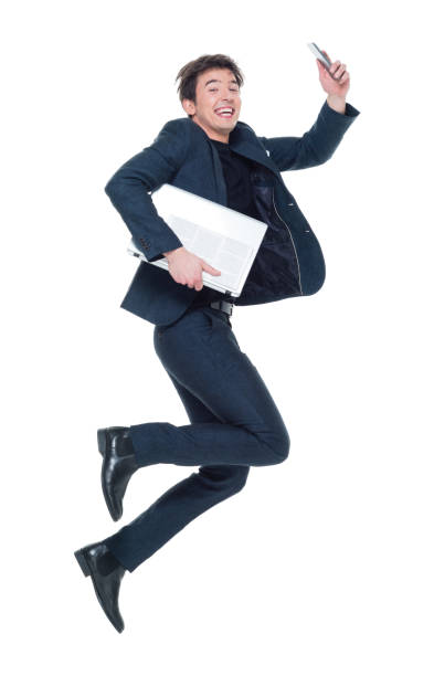 istock Charming young businessman jumping with phone and laptop 927274570