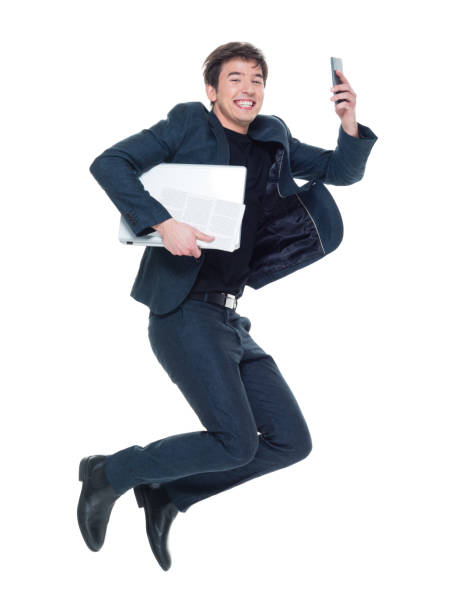 istock Charming young businessman jumping with phone and laptop 927274608