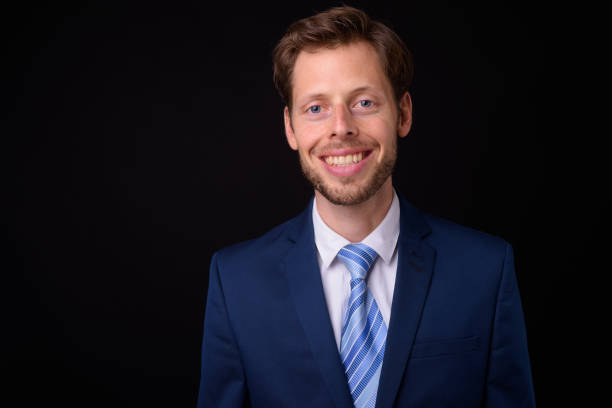istock Handsome businessman against black background 927280810