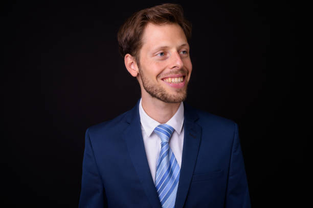istock Handsome businessman against black background 927280822