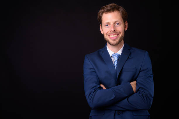 istock Handsome businessman against black background 927280824