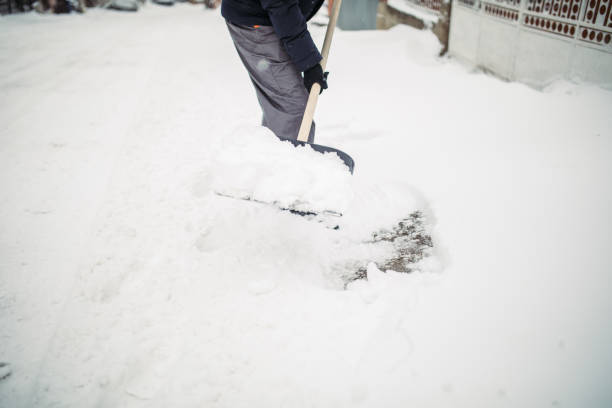 istock Man with snow shovel cleans sidewalk 927283124