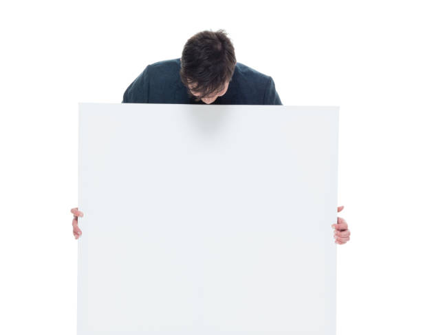 istock Attractive businessman hiding behind a white placard 927286984