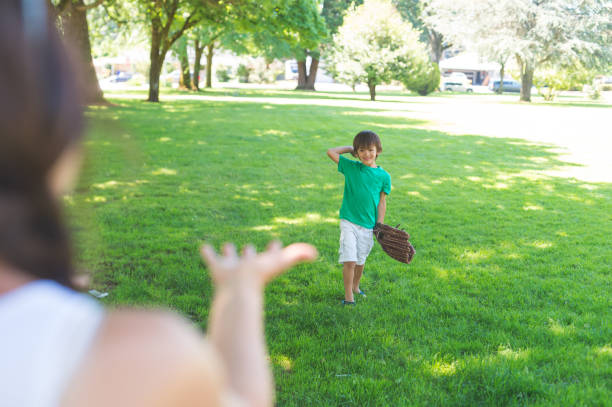 istock Mom and Her Boy Play Catch at the Park 927290540