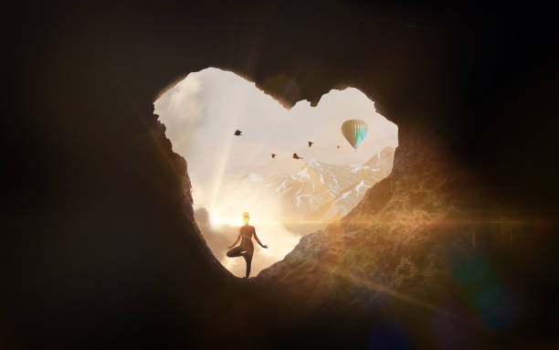 Woman doing yoga in cave shaped like a heart