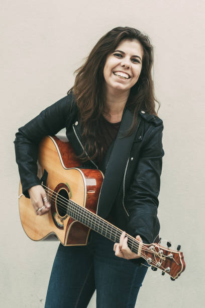 istock Smiling Young Woman Playing Guitar 927319100