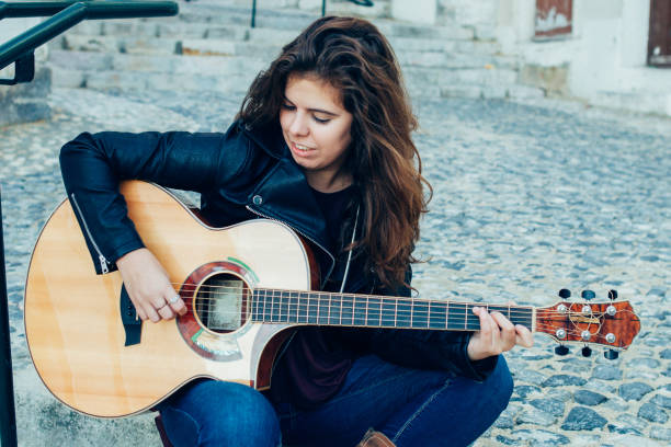 istock Content Young Woman Playing Guitar on Street 927319112