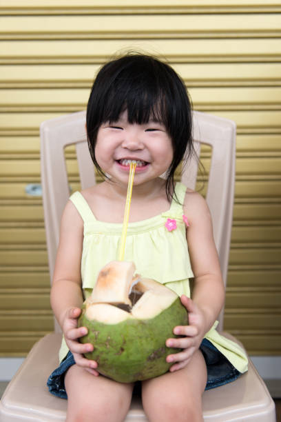 istock Cute girl drinking coconut water 927319442