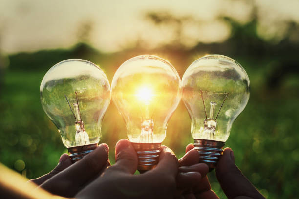 istock group hand holding lightbulb with sunset. concept idea solar energy 927319510
