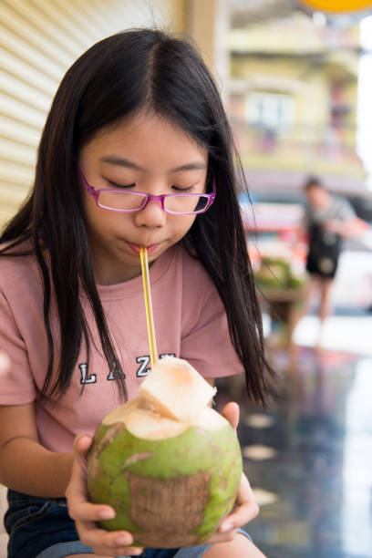 istock Cute girl drinking coconut water 927319538