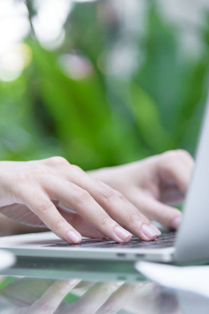 istock Asian woman hands has touching and typing on laptop computer with blurred coffee, computer and view outside window. 927327222