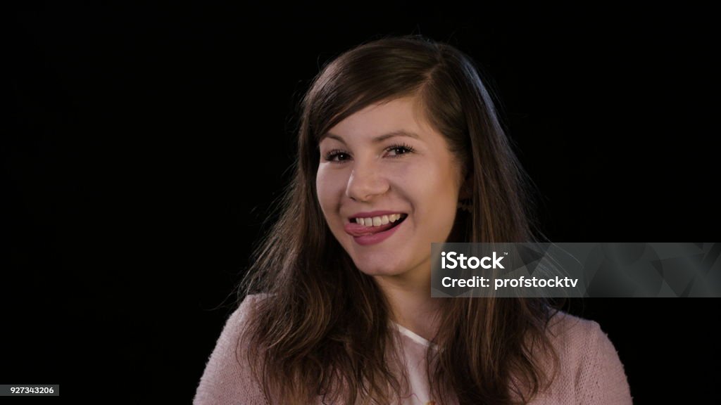 Una señora joven sonriente sobre un fondo negro - Foto de stock de Adolescente libre de derechos