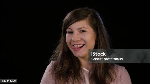 Una Señora Joven Sonriente Sobre Un Fondo Negro Foto de stock y más banco de imágenes de Adolescente - Adolescente, Adulto, Adulto joven