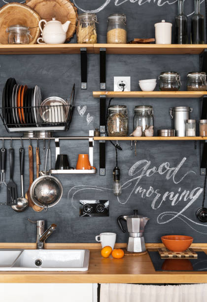 Design of modern kitchen in loft and rustic style. Wooden Shelves with different jars on a black wall with chalk "Good Morning" Design of modern kitchen in loft and rustic style. Wooden Shelves with different jars on a black wall with chalk "Good Morning" coffee maker in kitchen stock pictures, royalty-free photos & images