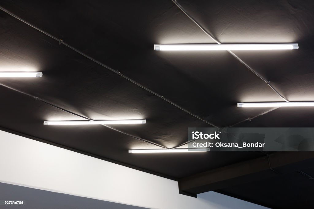 Led tube lights on black office ceiling. Minimal loft design Lighting Equipment Stock Photo