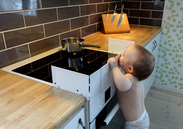 Curious baby child at the stove stock photo