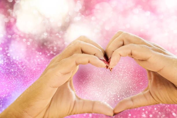 istock hands making heart shape on a romance pink glitter background for valentine 927351534