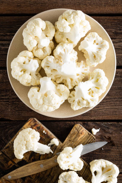 istock Fresh cauliflower on wooden board. Raw cauliflower. Top view 927352052