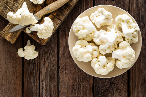 istock Fresh cauliflower on wooden board. Raw cauliflower. Top view 927352260