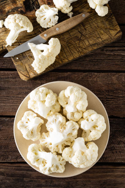 istock Fresh cauliflower on wooden board. Raw cauliflower. Top view 927352280