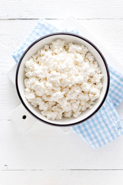 istock Cottage cheese, curd on white wooden rustic table, top view 927355290