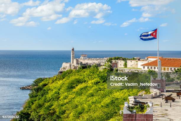 El Morro Spanish Fortress With Lighthouse Cannons And Cuban Flag In Th Foreground With Sea In The Background Havana Cuba Stock Photo - Download Image Now
