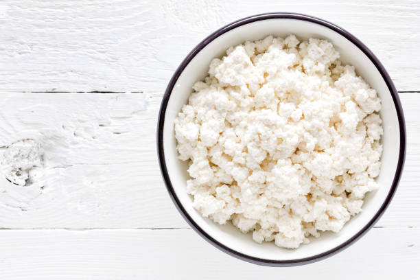 istock Cottage cheese, curd on white wooden rustic table, top view 927355472