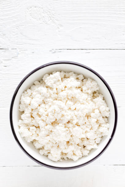 istock Cottage cheese, curd on white wooden rustic table, top view 927355474