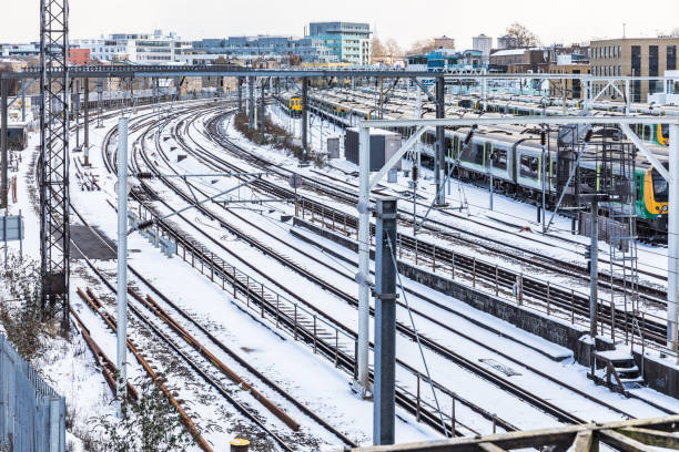 Rail tracks aerial view and trains covered by snow in London. UK capital city covered by snow after a powerful snowstorm. Travel and weather concepts related.