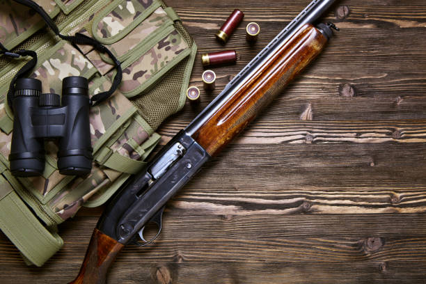 istock Hunting rifle and ammunition on a wooden background. 927358464
