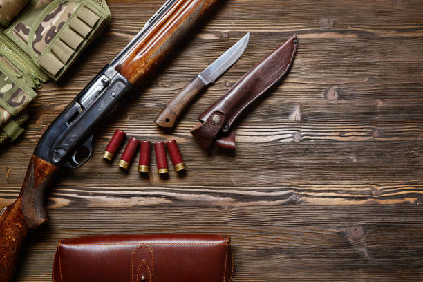 istock Hunting rifle and ammunition on a wooden background. 927358480