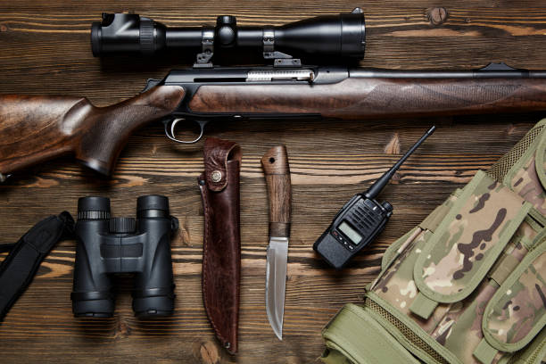 istock Hunting rifle and ammunition on a wooden background. 927358498