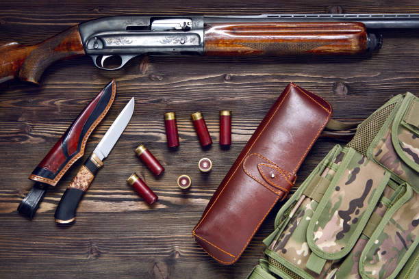 istock Hunting rifle and ammunition on a wooden background. 927358506