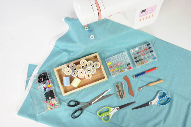 istock Sewing machine and colorful thread rolls, scissors, fabric and accessories for sewing on white background, Sewing and needlework concept. (Selective Focus) 927361528