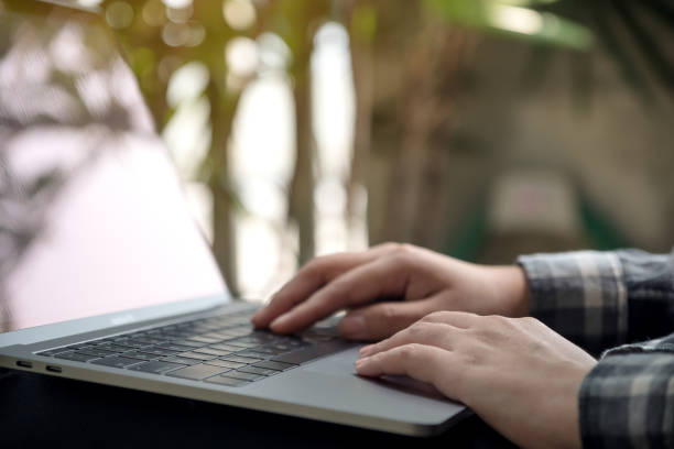 istock Closeup image of hands working , touching and typing on laptop keyboard with blur nature background 927362634
