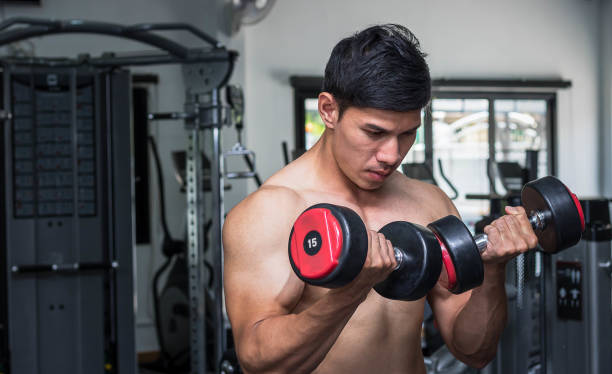 istock Men exercise in gym with dumbbell 927368806