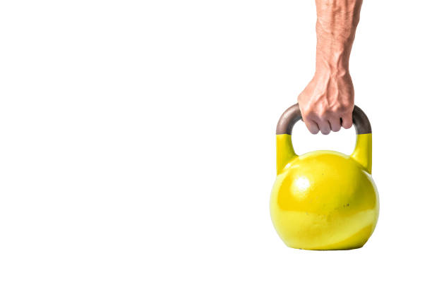 mano de hombre musculoso fuerte con músculos con kettlebell pesado amarillo parcialmente aislado sobre fondo blanco - gym yellow muscular build dumbbell fotografías e imágenes de stock