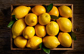 Fresh lemon fruits in a wooden box  on a wooden rustic table