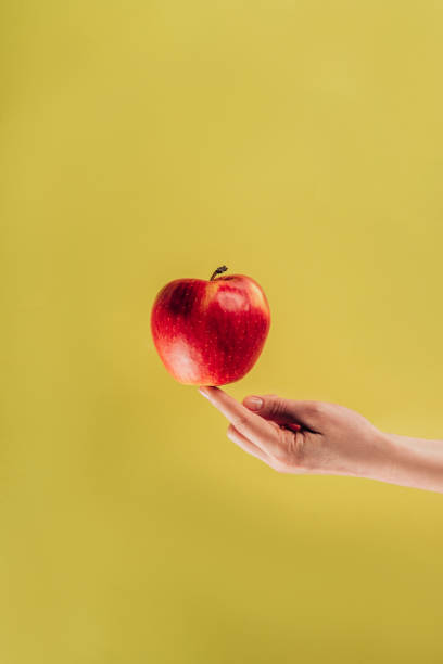 istock partial view of woman holding apple on finger 927390696
