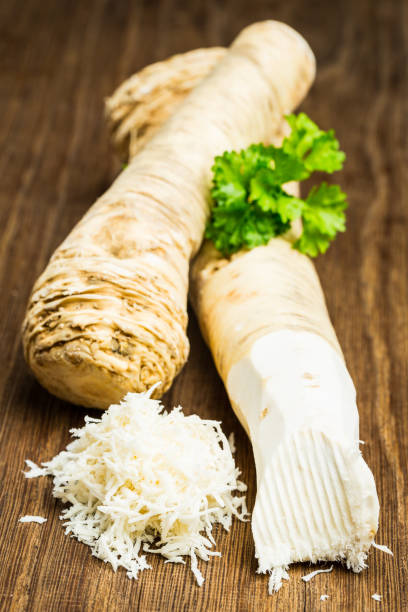 나무 보드에 두 개의 양 고추냉이 뿌리 - horseradish 뉴스 사진 이미지