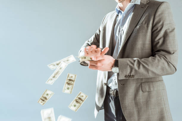 istock Close-up view businessman throwing money isolated on grey 927394300