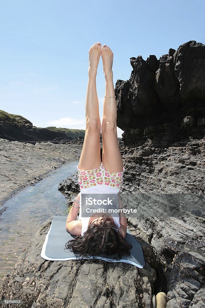 Lo yoga sulle rocce stretching - Foto stock royalty-free di Adulto